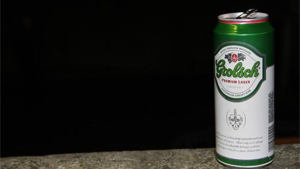 A can of Grolsch lager on a wall at night