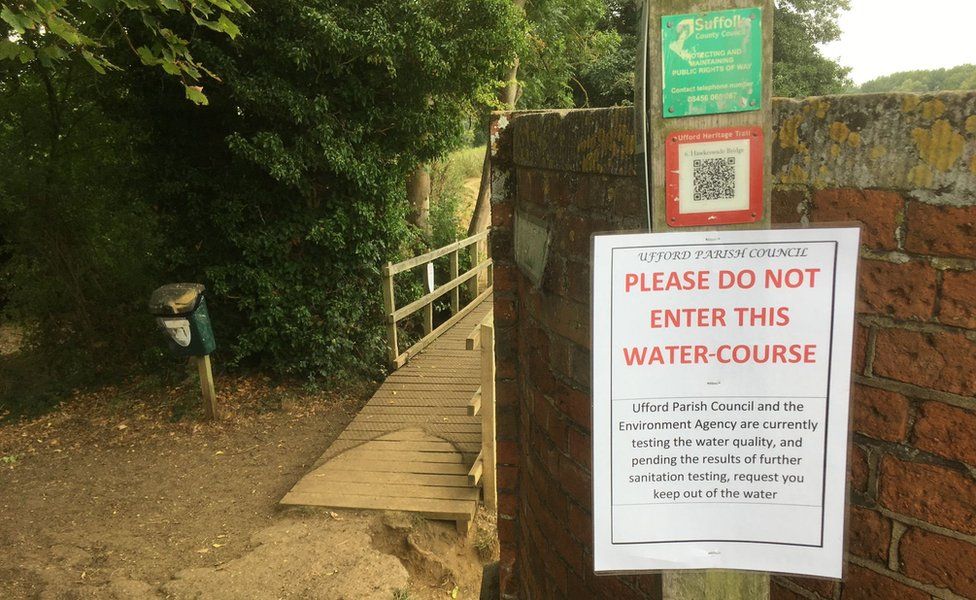 A warning sign that has been put up by Ufford Parish Council warning people not to enter the water due to water quality tests taking place