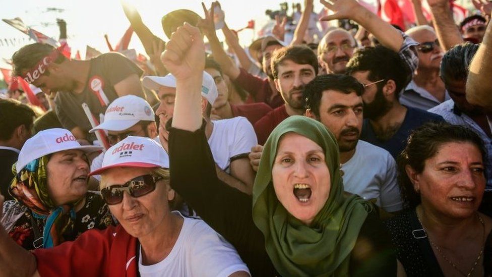 People cheer as Turkey's main opposition CHP leader Kemal Kilicdaroglu throws flowers to supporters during a rally in Istanbul (09 July 2017)