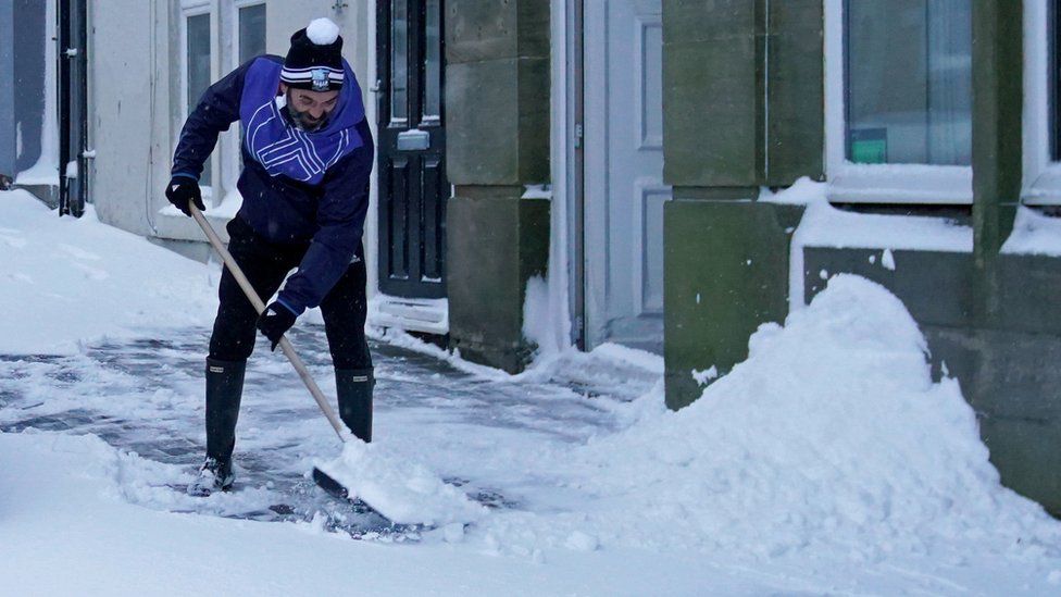 A man shovels snow in Tow Law