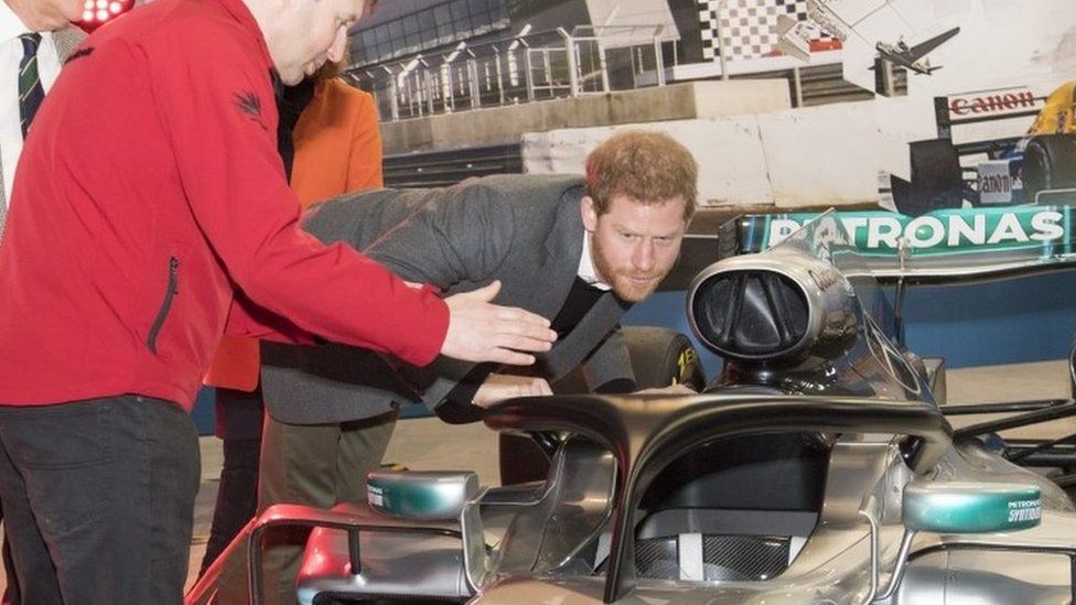 Prince Harry, studies the "Halo" on Lewis Hamilton"s Mercedes, a new safety addition to Formula 1 cars this year, during a visit to the Silverstone Circuit in Northamptonshire