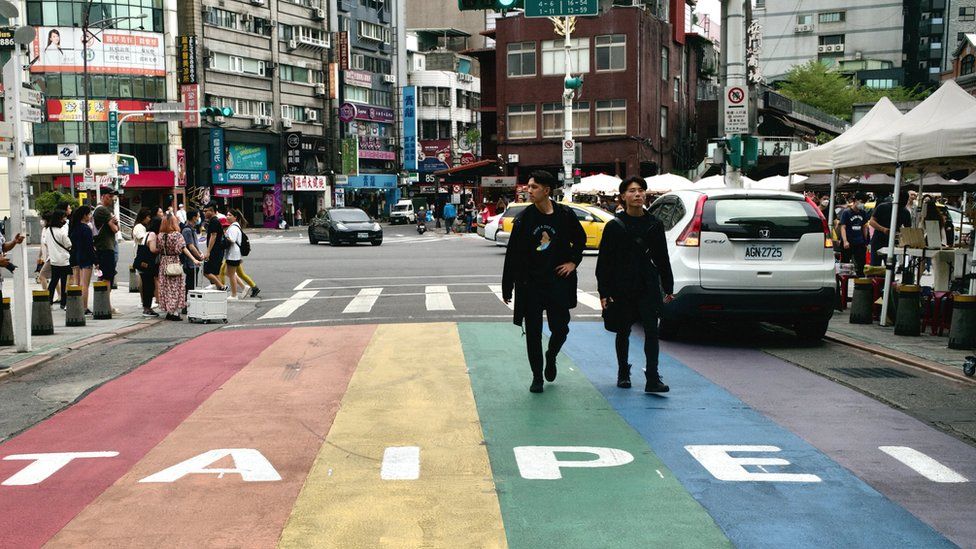 This picture taken on April 14, 2023 shows people walking down a street at the Ximen district in Taipei.