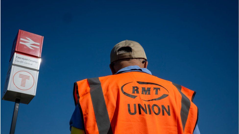 Man in a RMT union hi-vis jacket at Cardiff Central station