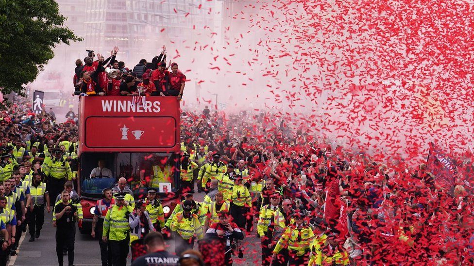 Liverpool players ride on an open-top bus during the trophy parade in Liverpool