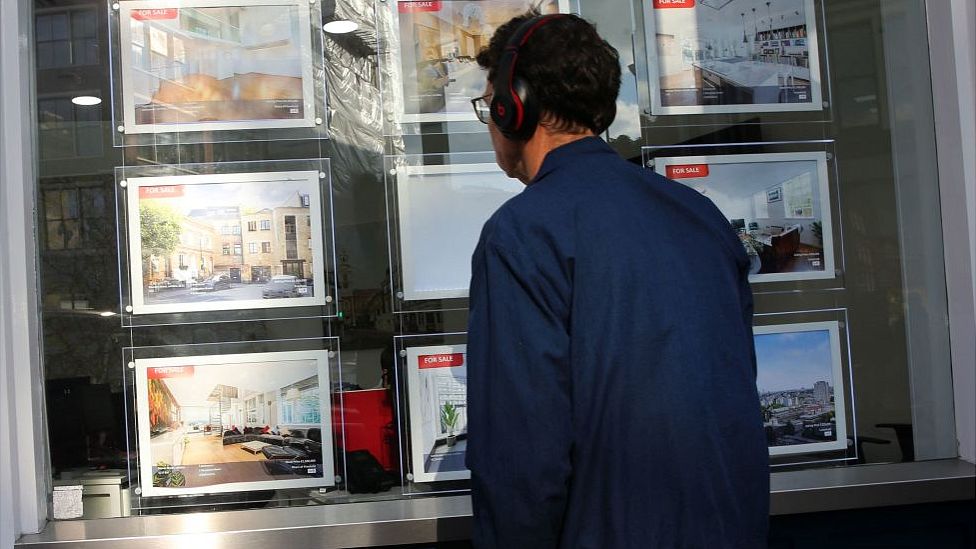 Man looks in estate agents' window