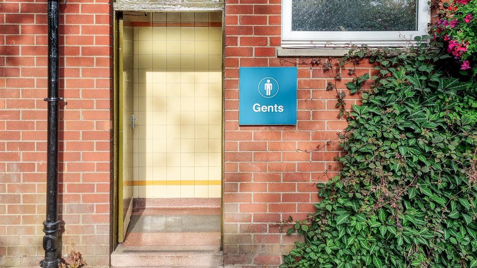 An exterior view of the gents entrance to a traditional public toilet building in the UK