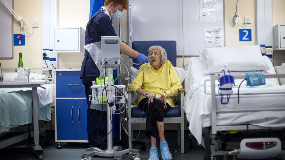 A rehab support worker checks patient Shirley Hughes, 86, as the first patients are admitted to NHS Seacole