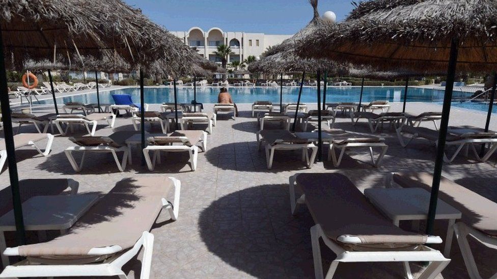 A tourist sits on a sunbed next to a hotel pool on the Tunisian resort island of Djerba on May 26, 2016