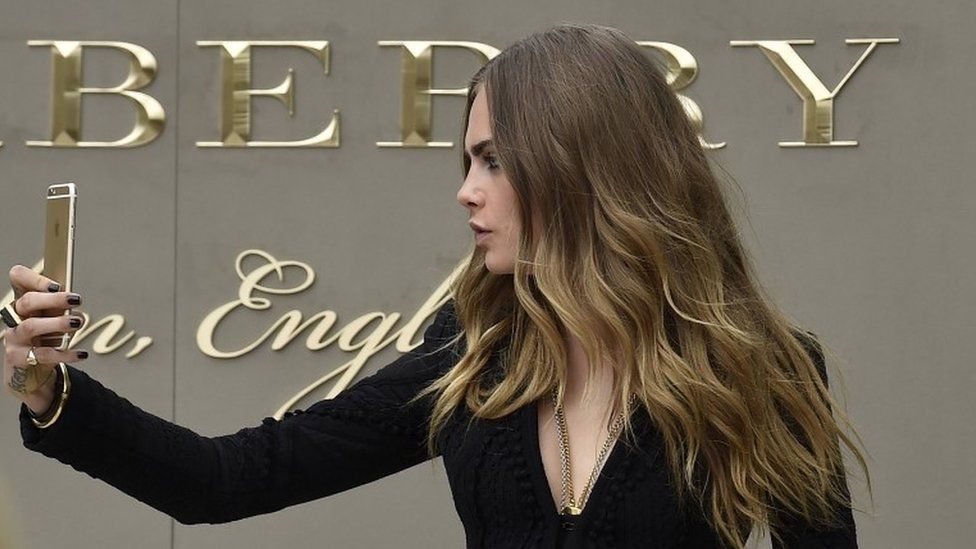 British Model Cara Delevinge takes a selfie at the spring/summer 2016 Burberry collection