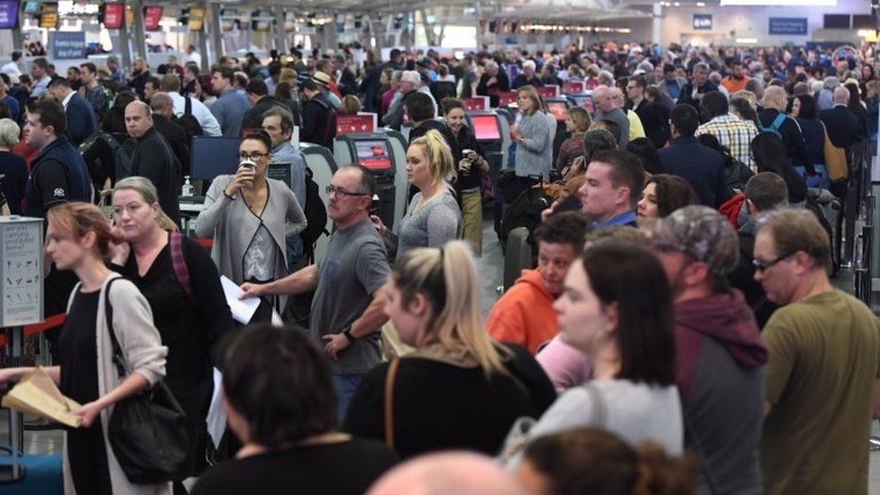 A large crowd of passengers queue up at Sydney Airport on Monday
