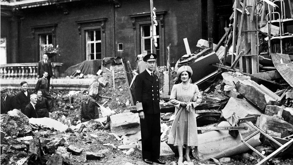 King George and the Queen Mother pictured next to a bomb-damaged Buckingham Palace in 1940