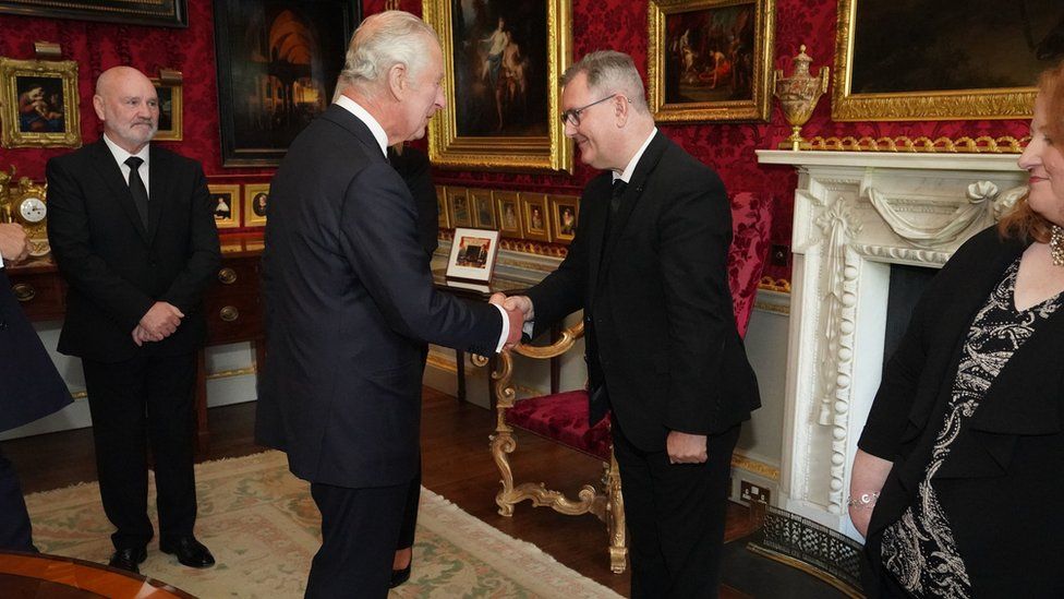King Charles and Democratic Unionist Party leader Sir Jeffrey Donaldson shake hands inside Hillsborough Castle