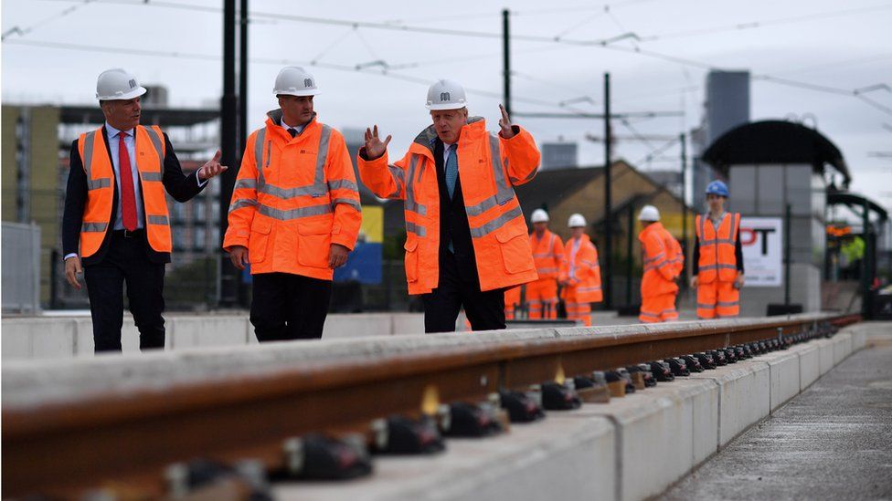 Boris Johnson walking alongside a tram track