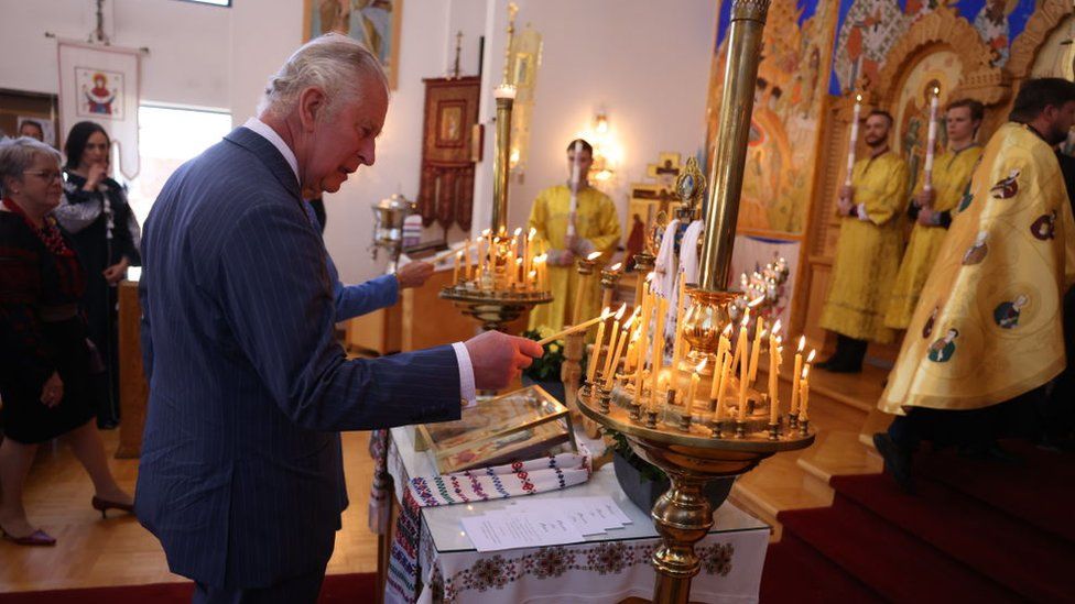 The Prince of Wales lights a candle in a Ukrainian cathedral in Ottawa, Canada