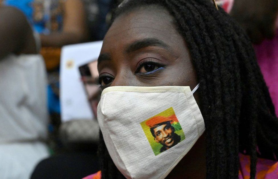 An attendee wears a protective face mask with an image of Burkina Faso's former President Thomas Sankara.