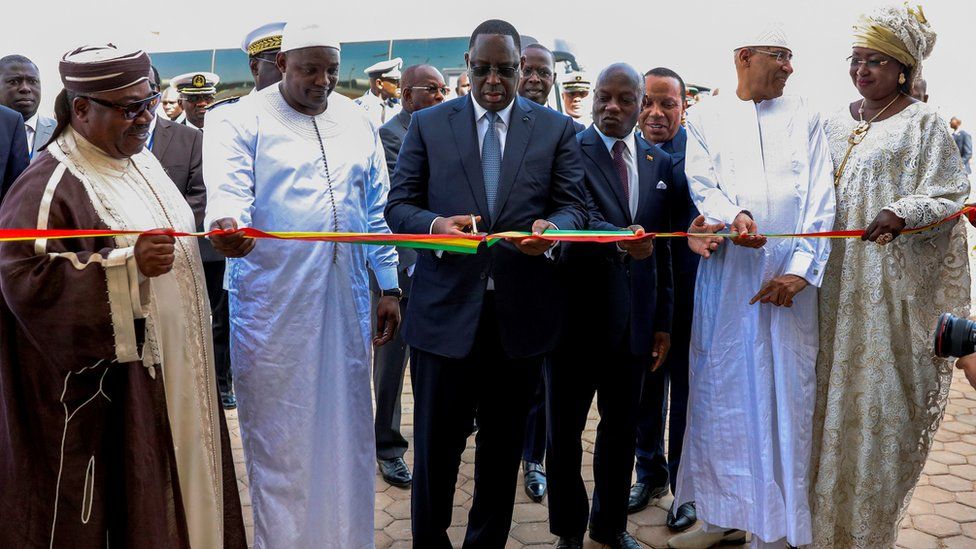 Senegal's President Macky Sall (C) is watched by his wife Marieme Faye Sall (R) and regional leaders as he cuts a ceremonial ribbon at the opening ceremony for the new Blaise Diagne International Airport - 7 December