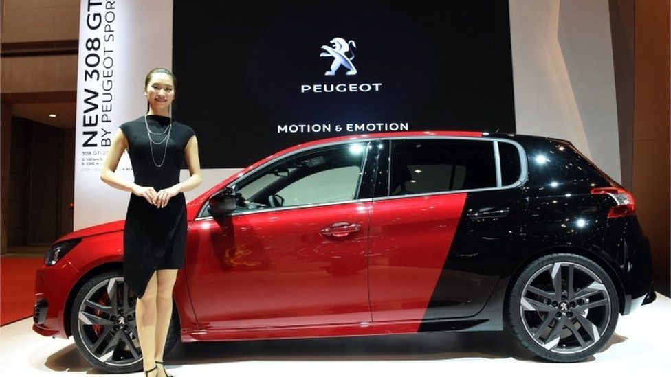 woman in front of Peugeot car