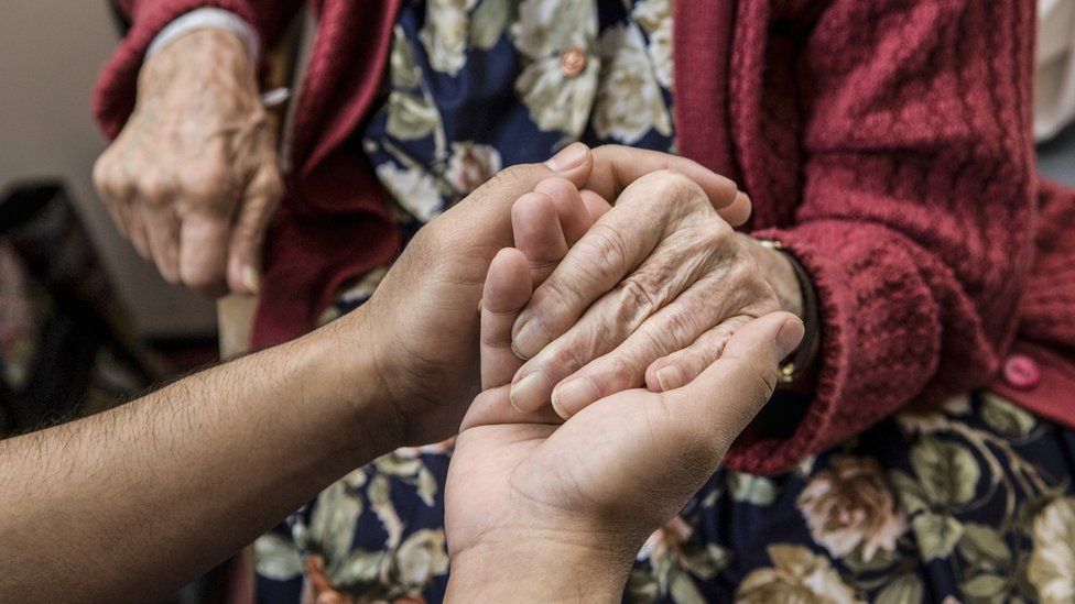 Holding an older person's hand