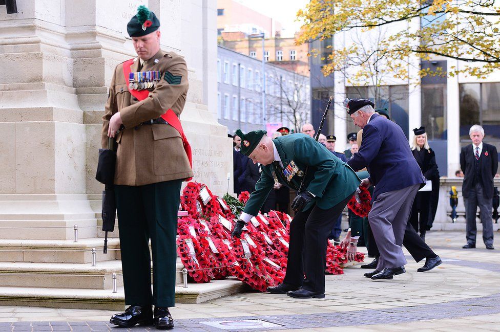 Men lay wreaths at the Cenotaph at Belfast City Hall