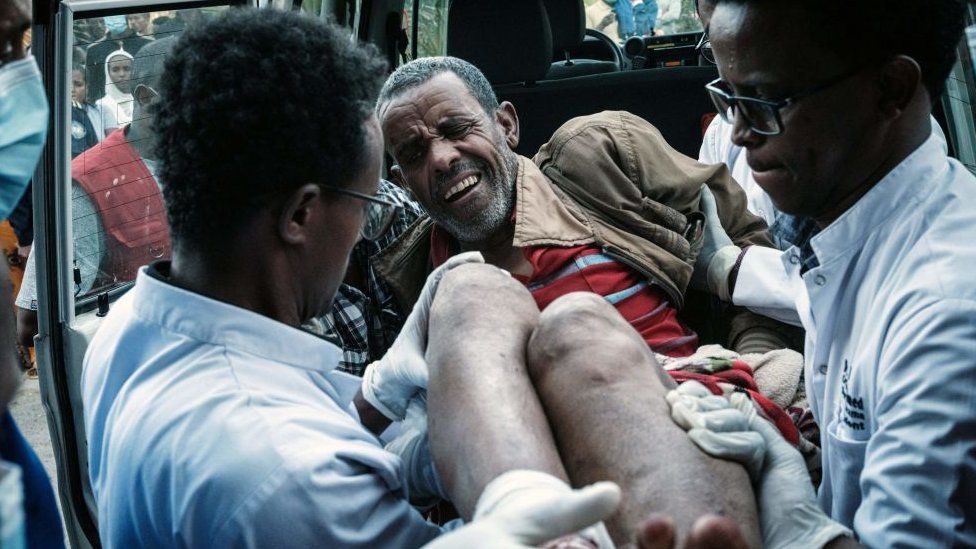 An injured man is carried out of an ambulance by doctors