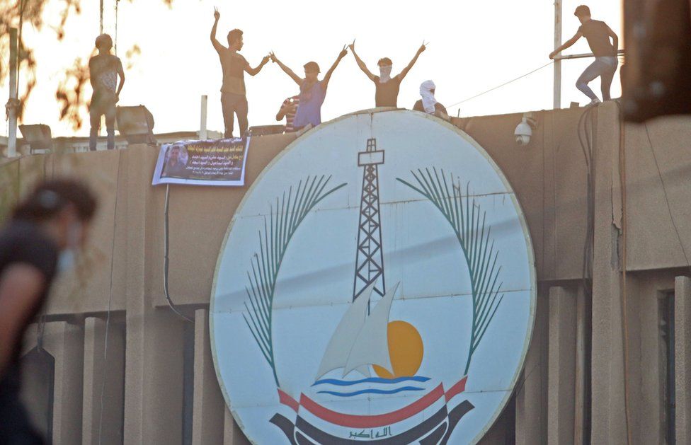 Protesters stand on top of an official building in Basra, 6 September 2018