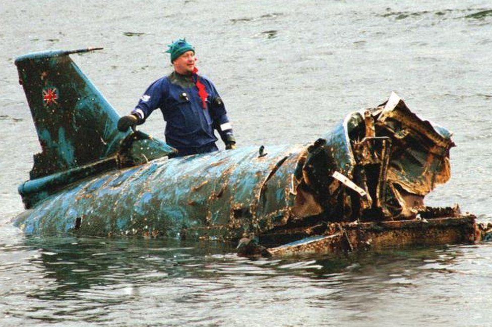 Bill Smith with the wreckage of Bluebird, which had been lifted from Coniston Water in 2001