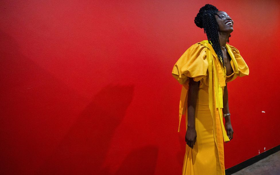 A model in a yellow dress laughing backstage at Soweto Theatre, South Africa - Friday 5 May 2023