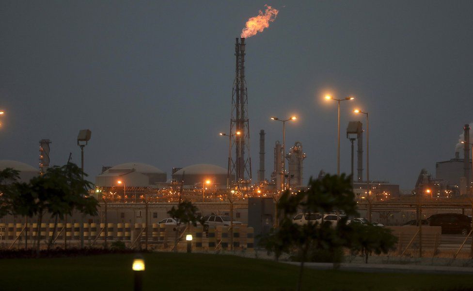 Lights illuminate a phosphate processing plant as a flame burns from a chimney in Saudi Arabia