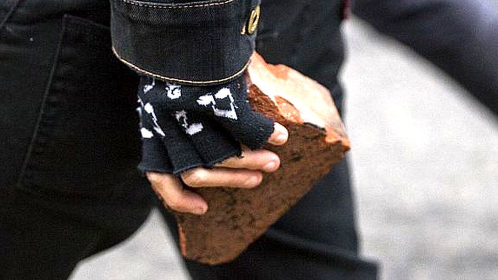 Protester with a brick in their hand