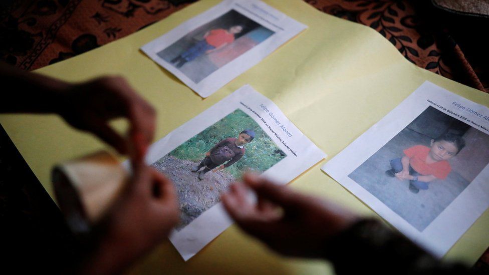 The family of Felipe Alonzo-Gomez arranges photos of the dead boy in the village of Yalambojoch, Guatemala, 27 December