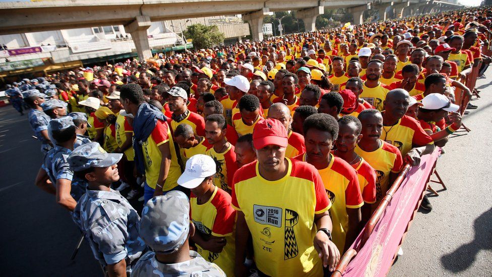 Big line of athletes wearing red and yellow running tops in Addis Ababa, Ethiopia - Sunday 20 November 2016