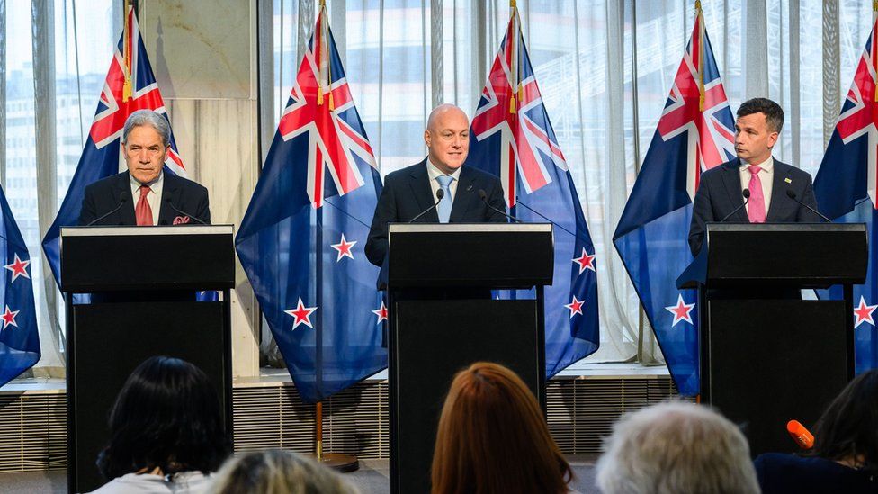 Ο νέος πρωθυπουργός της Νέας Ζηλανδίας Κρις Λούξον (κέντρο) με τους εταίρους του στο συνασπισμό Γουίνστον Πίτερς (αριστερά), αρχηγό του κόμματος Πράξη Νέας Ζηλανδίας και Ντέιβιντ Σέιμουρ (δεξιά), ηγέτη του κόμματος Act