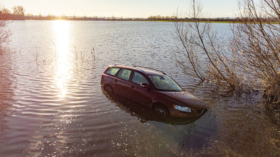 A car is stranded in floodwaters on Langport Road, near Muchelney, Somerset.