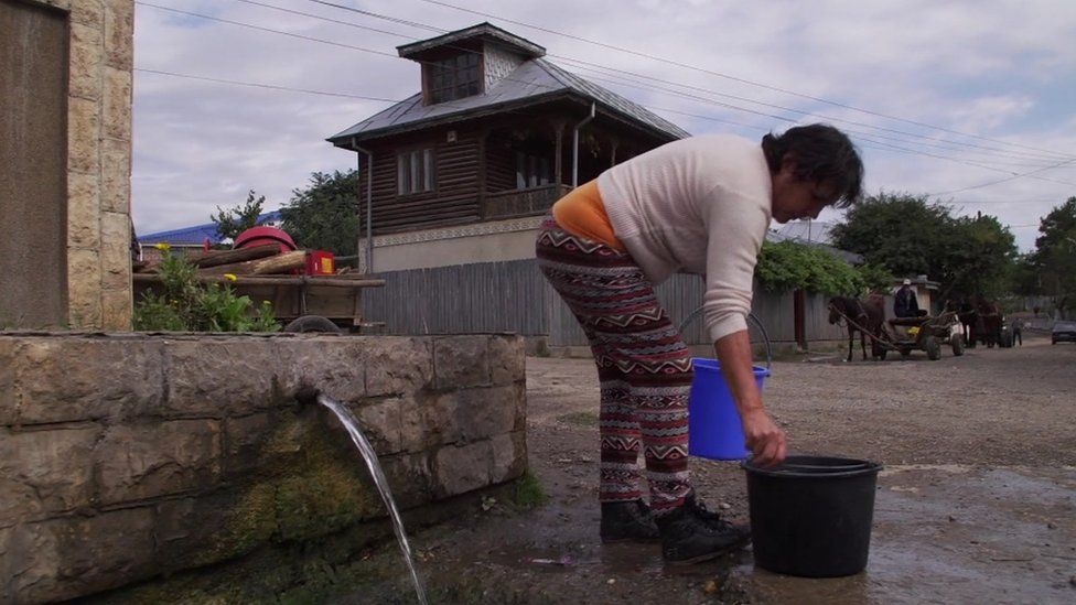 A woman in Nicoresti with buckets of water