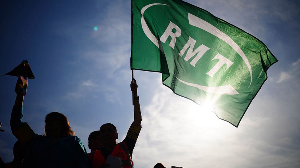A green RMT flag is held in the air on a picket line outside Bristol Temple Meads station, as members of the Rail, Maritime and Transport union begin their nationwide strike in a bitter dispute over pay, jobs and conditions.