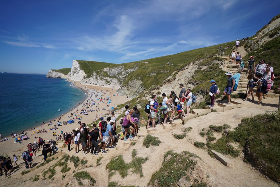 People make their way down steps to Durdle Door beach in Dorset