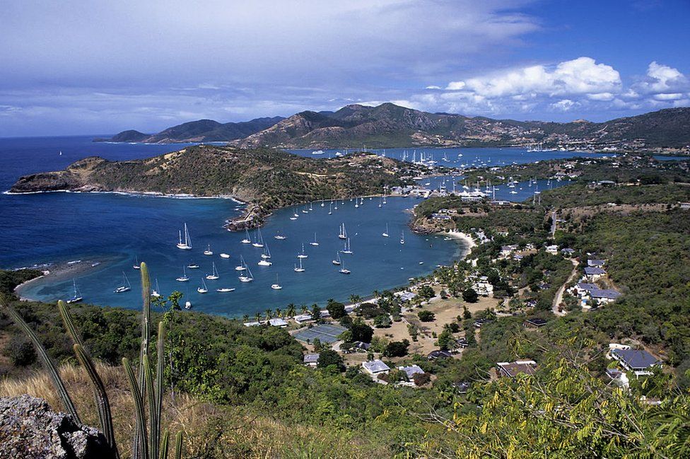 A view of English Harbour and Nelson's Dockyard in Antigua, showing a bay full of yachts against the blue sea