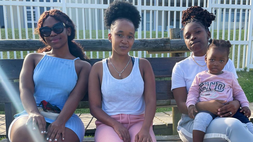Sanele Shabalala (R) and her sisters on a bench in KwaZulu-Natal in South Africa - December 2021