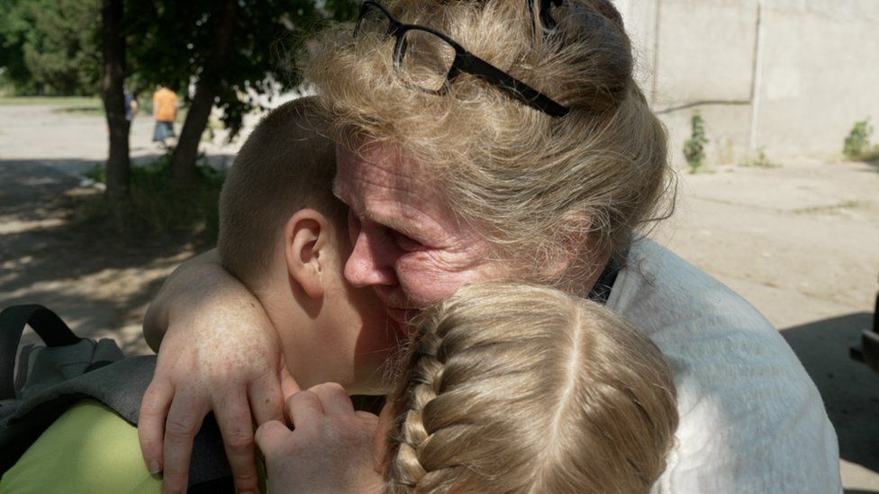 Liudmyla hugs her children goodbye