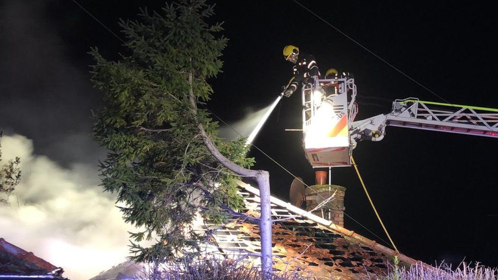 A fire fighter tackles the fire from a platform ladder