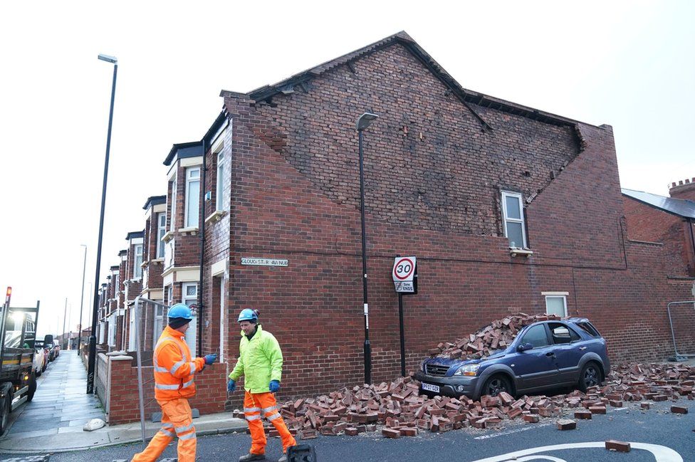 Bricks lying on car having fallen off wall