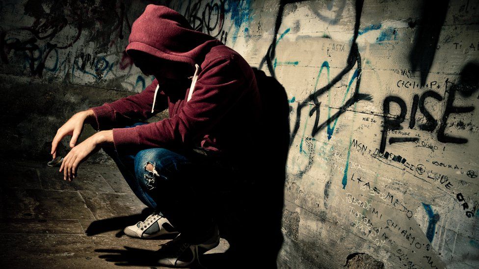 Anonymous teenager in dark corner