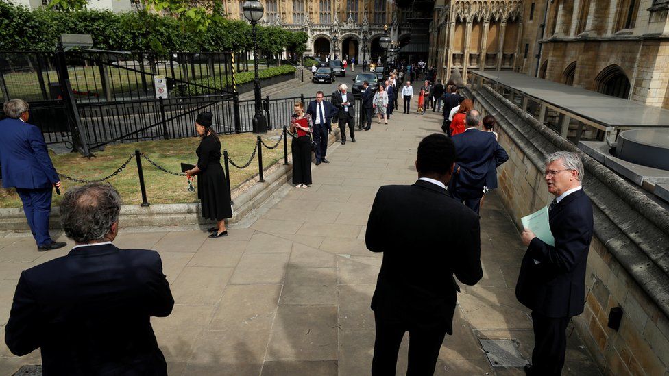 MPs are seen queuing outside Parliament before voting on whether to end special coronavirus measures in Parliament, following the outbreak of the coronavirus disease (COVID-19), London, Britain