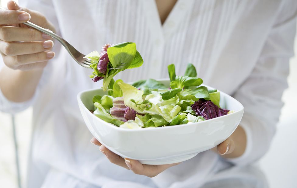 Detail of woman eating salad