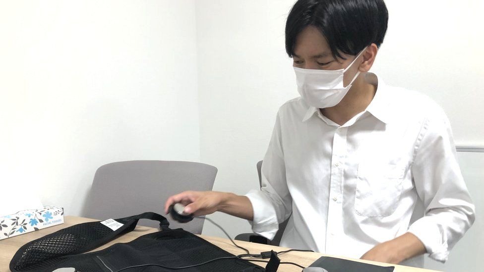 Yoshinori Kato demonstrates the components of a cooling vest