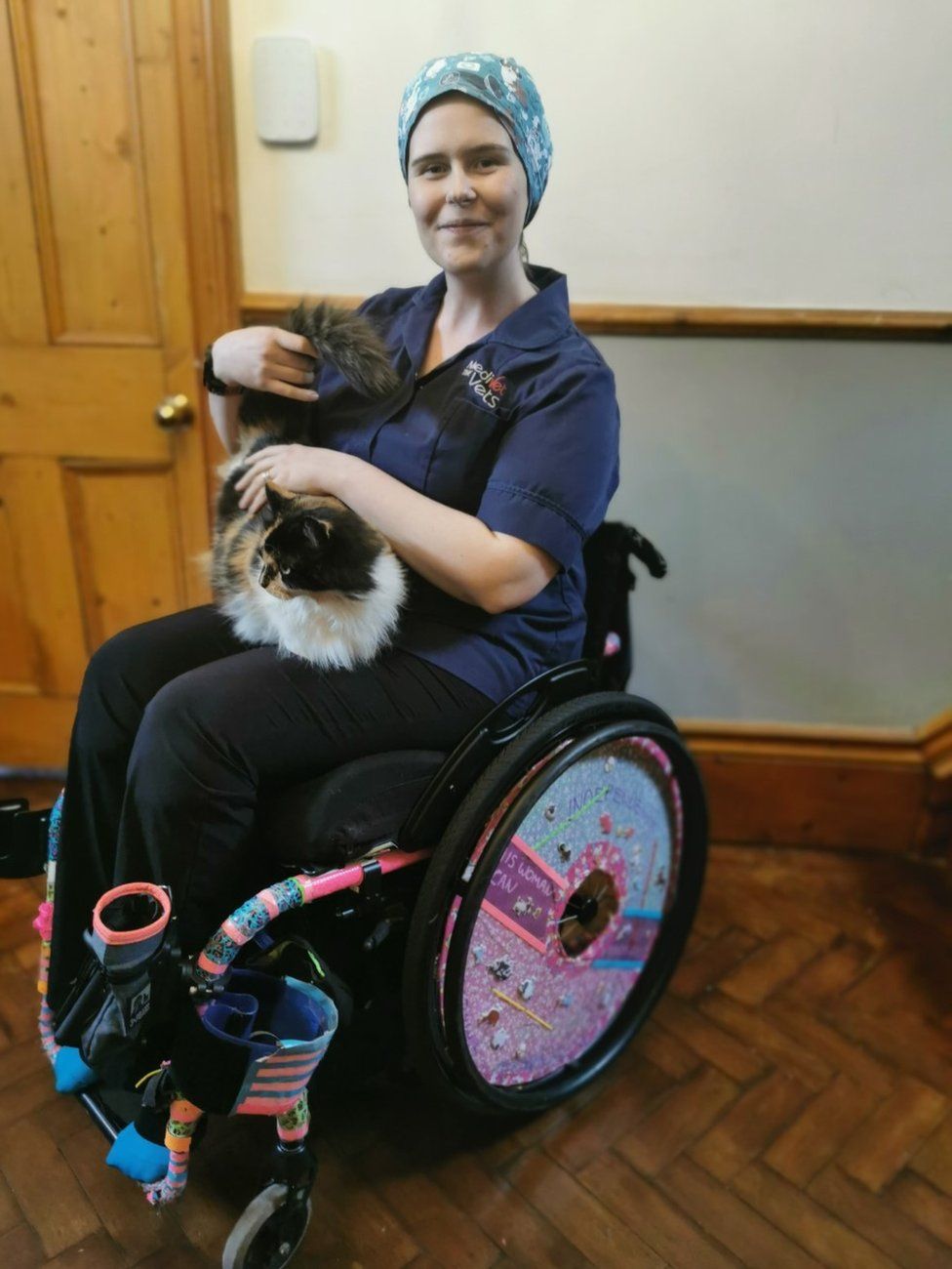 Dr Kiah Hann in a wheelchair with a cat