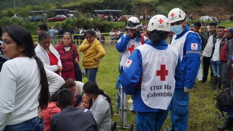 Red Cross personnel look on during search and rescue operations at site of a landslide in Narino, Colombia, January 21, 2018