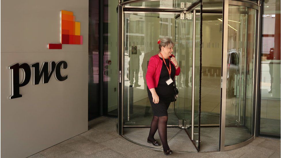 A woman walks into the PwC building in London
