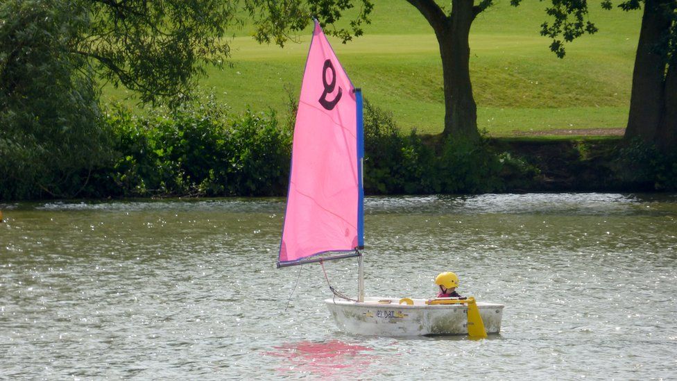 A boy in a sailing boat at Sutton Park