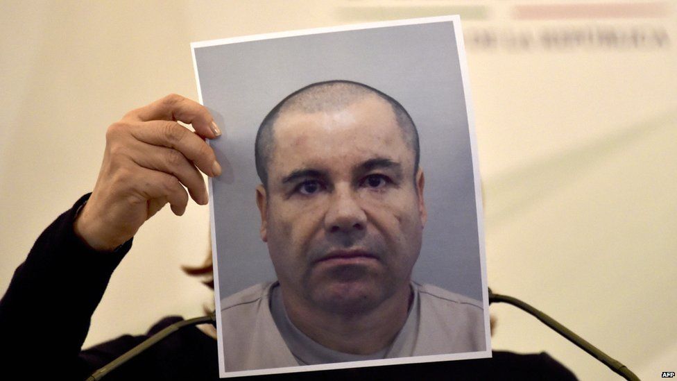 Attorney-General Aerly Gomez holds up a picture of wanted top drug lord Joaquin Guzman